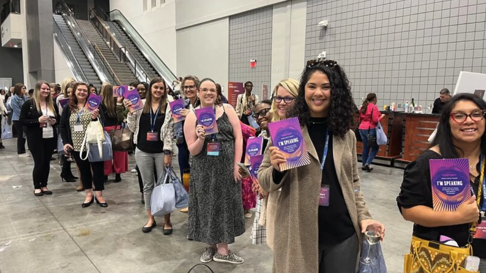 Conference attendees holding copies of I'm Speaking.